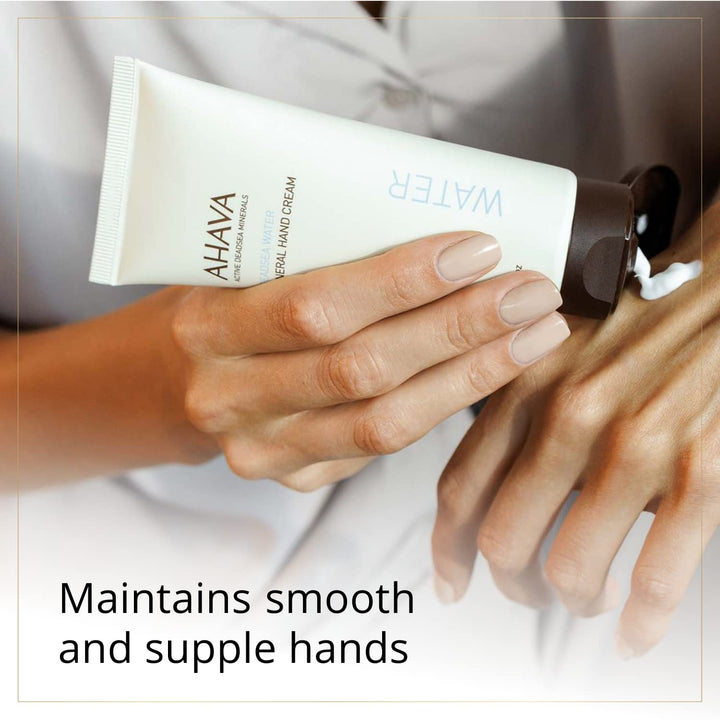 Person applying Ahava hand cream to their hands with a blurred background