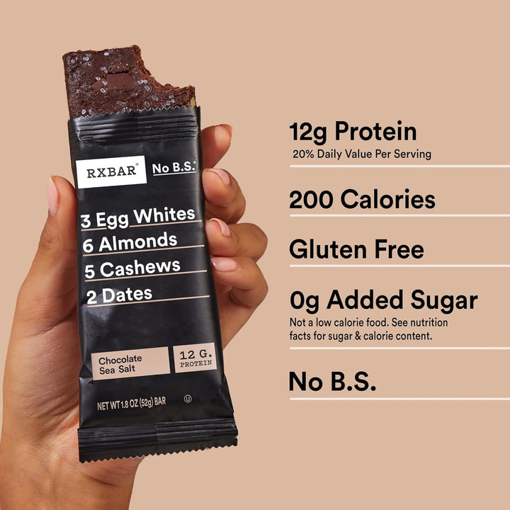 RXBAR protein bar held by a hand with nutritional information on a beige background