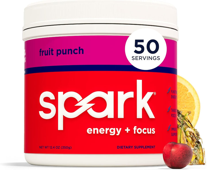 A white tub of Spark Energy + Focus dietary supplement in fruit punch flavor, with a bright red and magenta label, shown on a white background with a lemon slice and apple graphic.