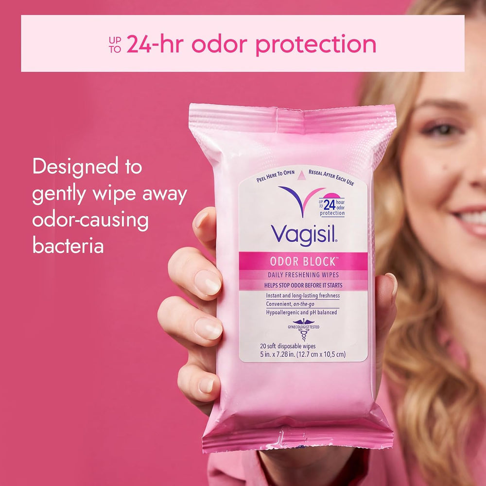 A person holds a package of Vagisil Odor Block reusable wipes against a pink promotional background with text about odor protection.