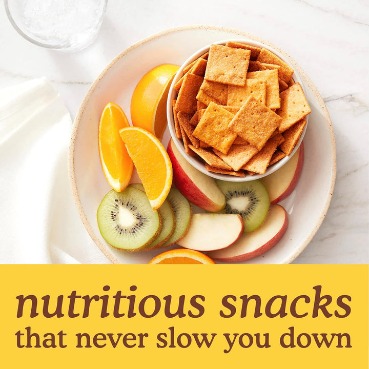 Assorted snacks including crackers, fruits, and a glass of milk on a marble surface with text 'nutritious snacks that never slow you down'.