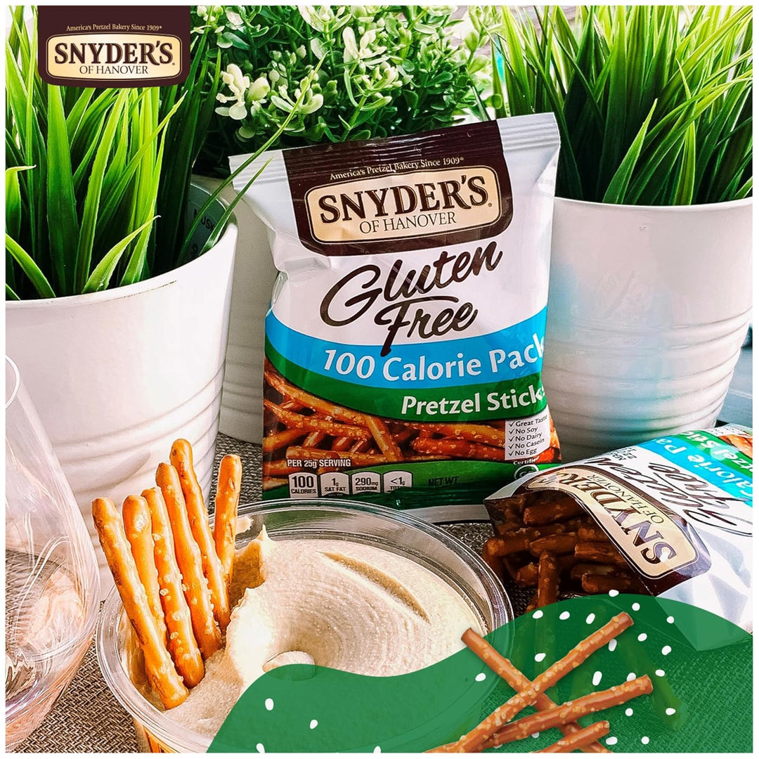 Snyder's of Hanover gluten-free pretzel sticks with a bowl of dip and plants in the background.
